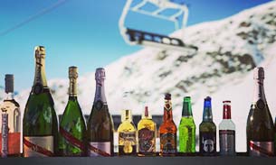 Bottles of champagne and wine under a chairlift at a mountain hut.