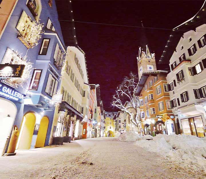 A snowy pedestrian street in the old town of Kitzbuhel at night