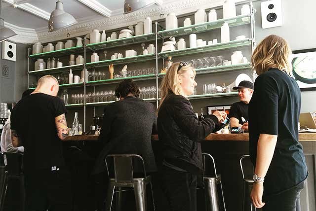 People talking at the counter of a cafe