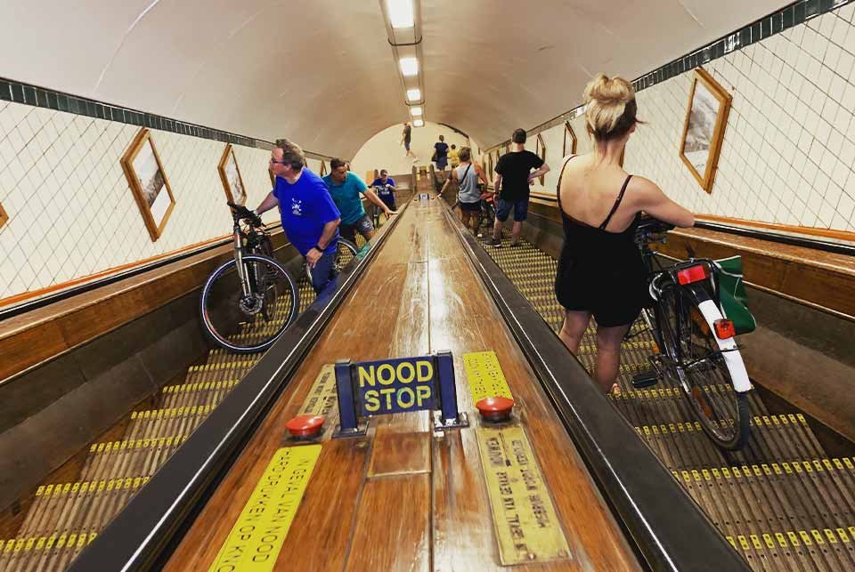 People conveying their bikes on an escalator in Antwerp