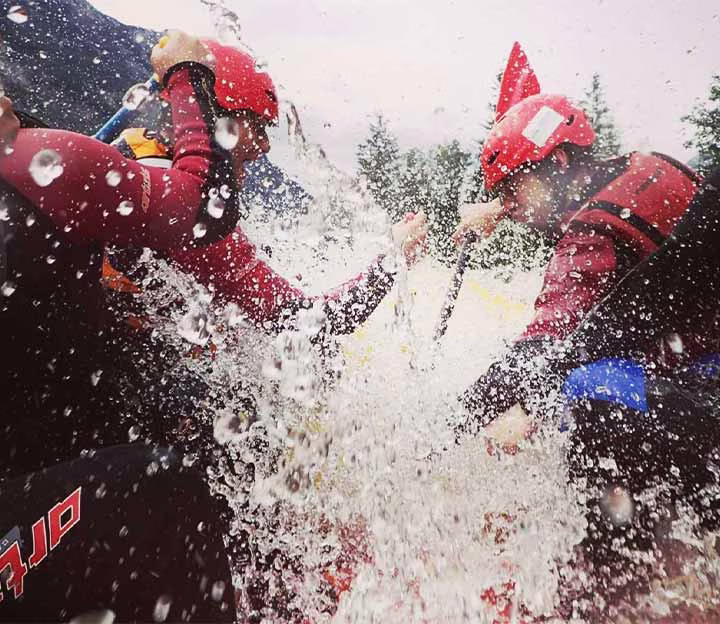 People paddling in a white water raft