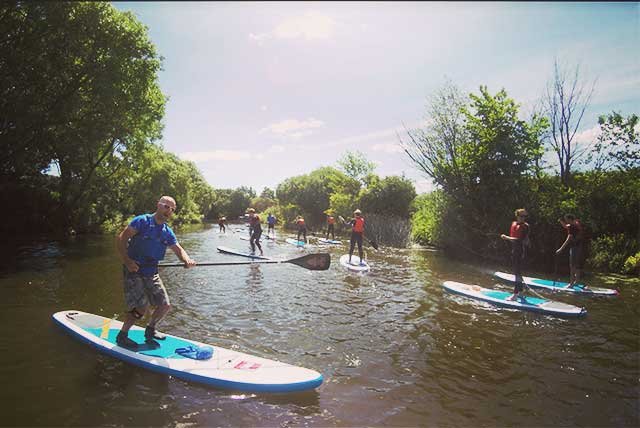 People stand up paddling on a river