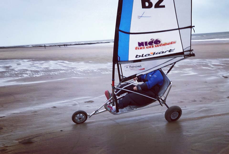 Land yacht sailing across a beach on 2 wheels