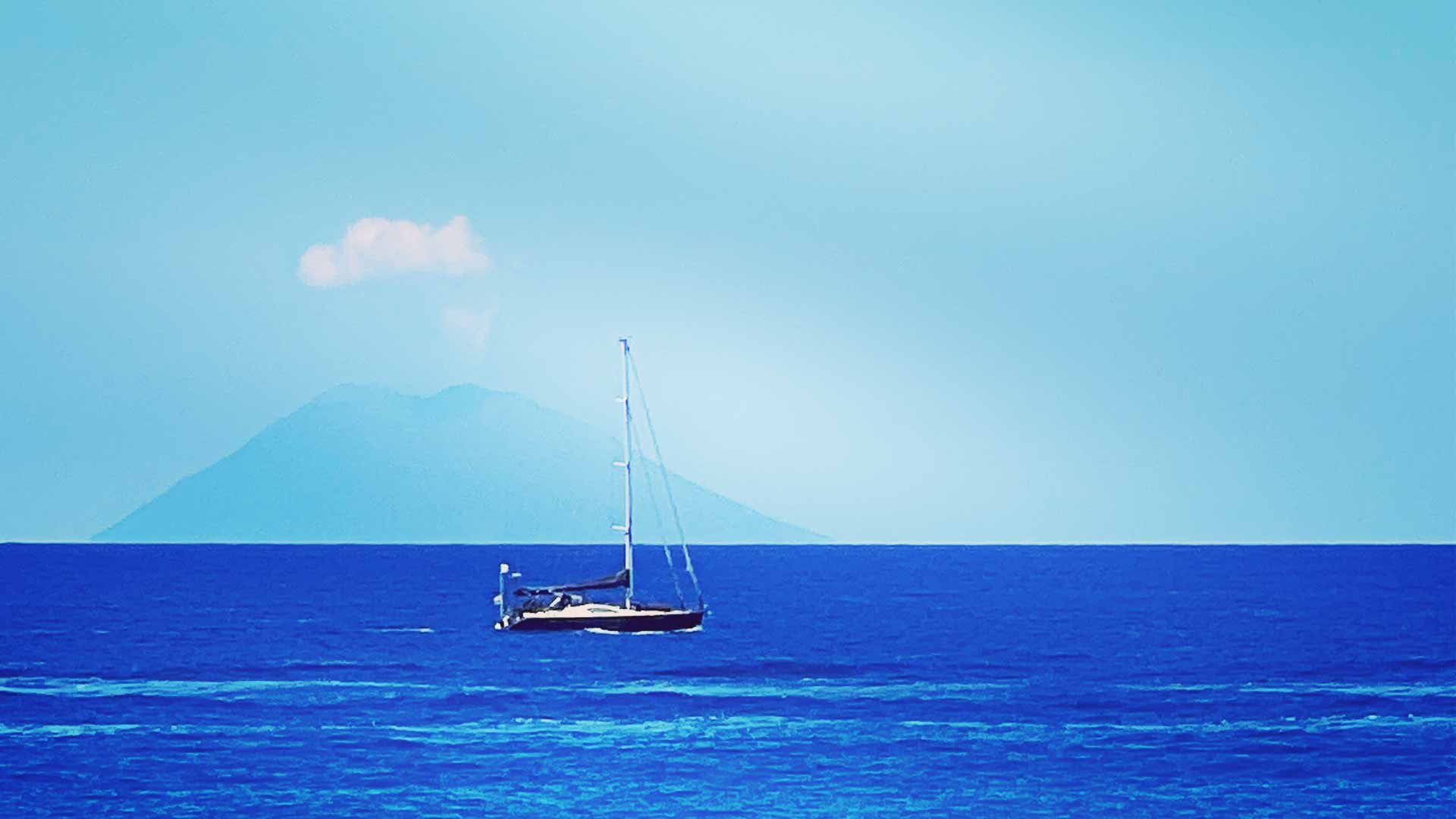Yachts sailing in front of Stromboli volcano