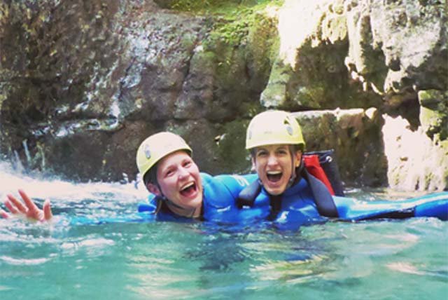 Two people in the water of a canyon