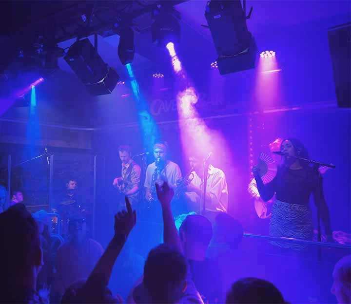 People dancing under strobe lights to a live band