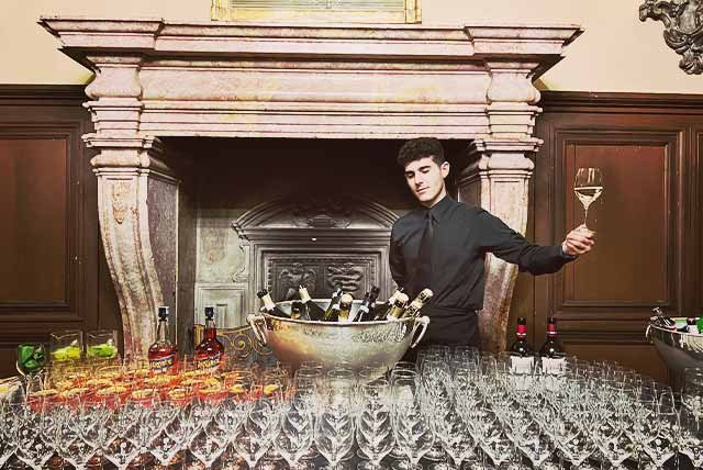 waiter holding up a glass of wine