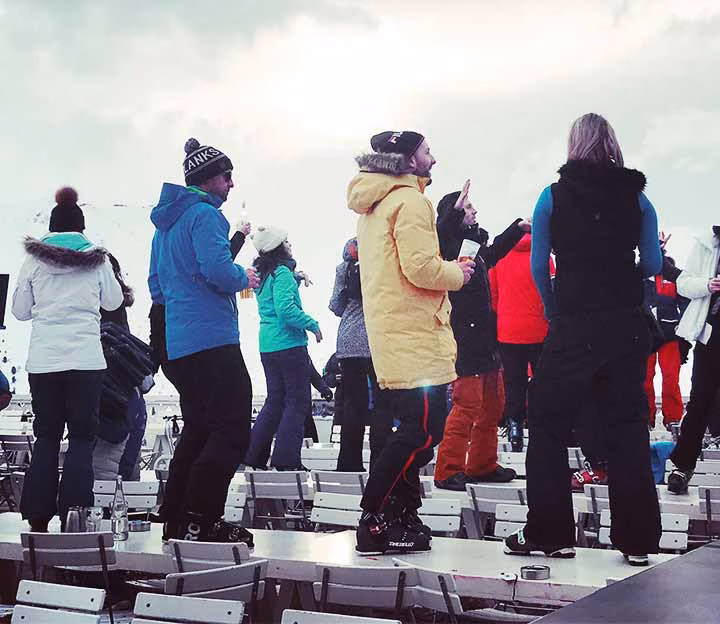 Skiers dancing on tables at apres ski