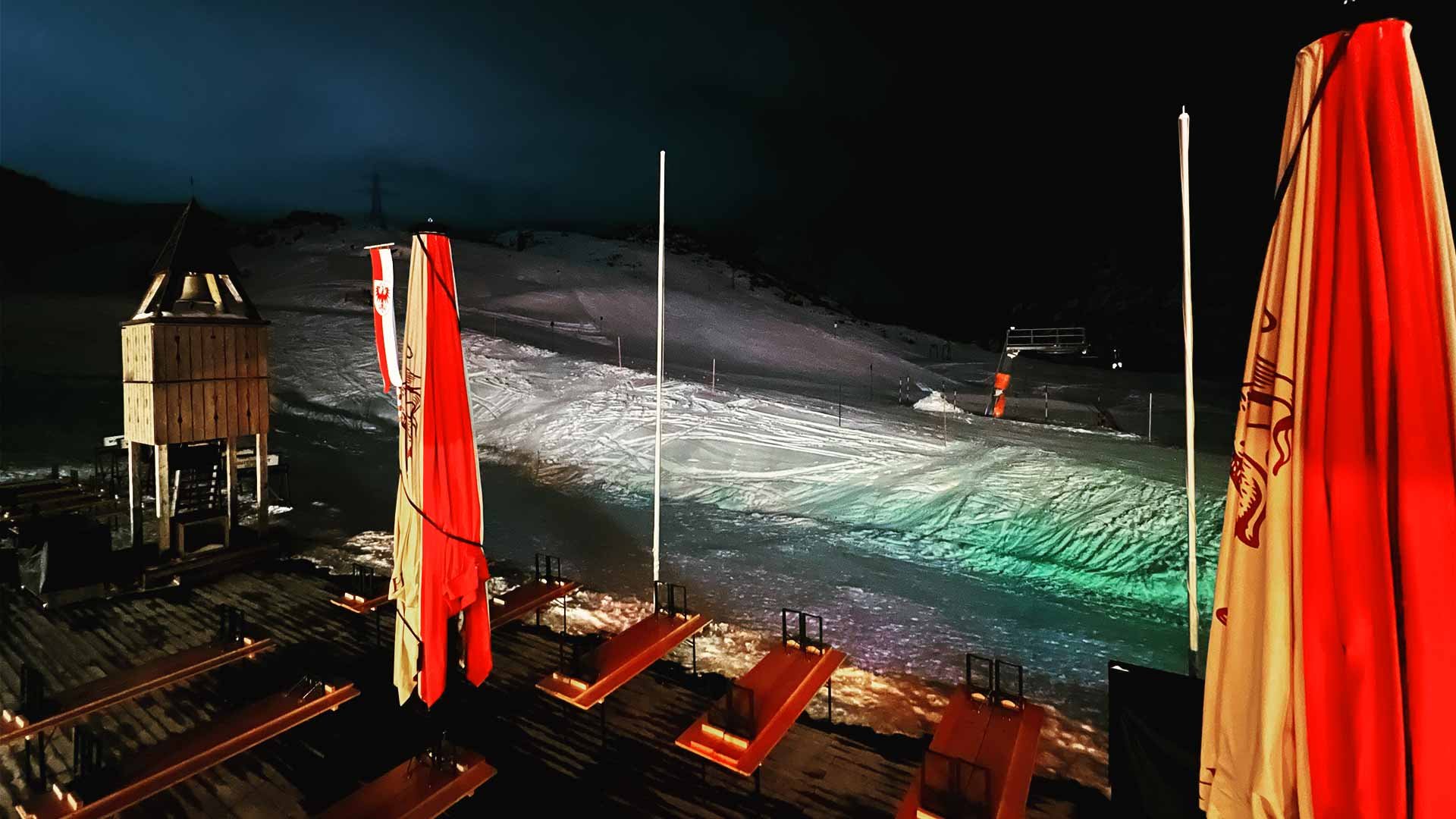 Hut terrace at night overlooking a ski piste