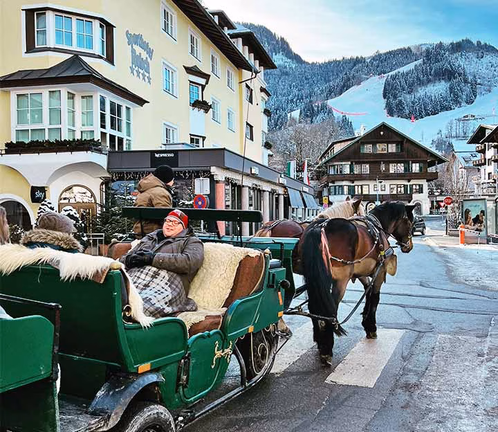 Horse drawn carriage on a road in a snowy resort