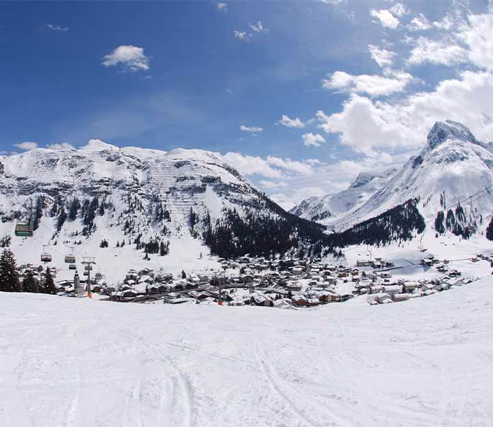 A ski piste with a village in the distance