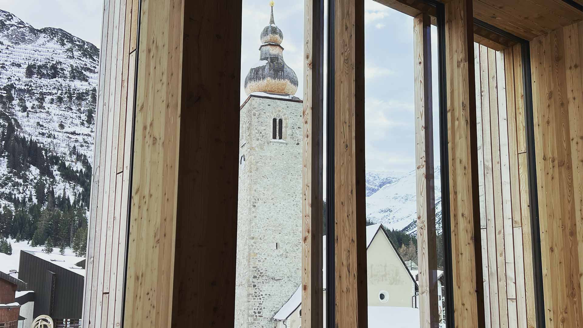 Views of a mountain church through a wooden window