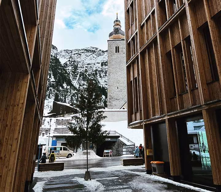 View of Lech church between wooden buildings in the mountains