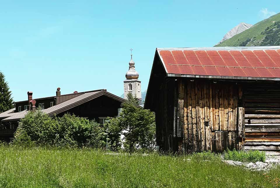 Barn and church in a field in a mountain resort