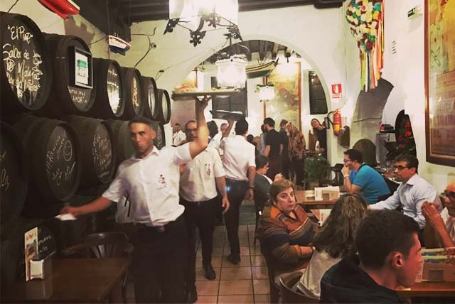 Waiter carrying a tray in a busy restaurant in Malaga