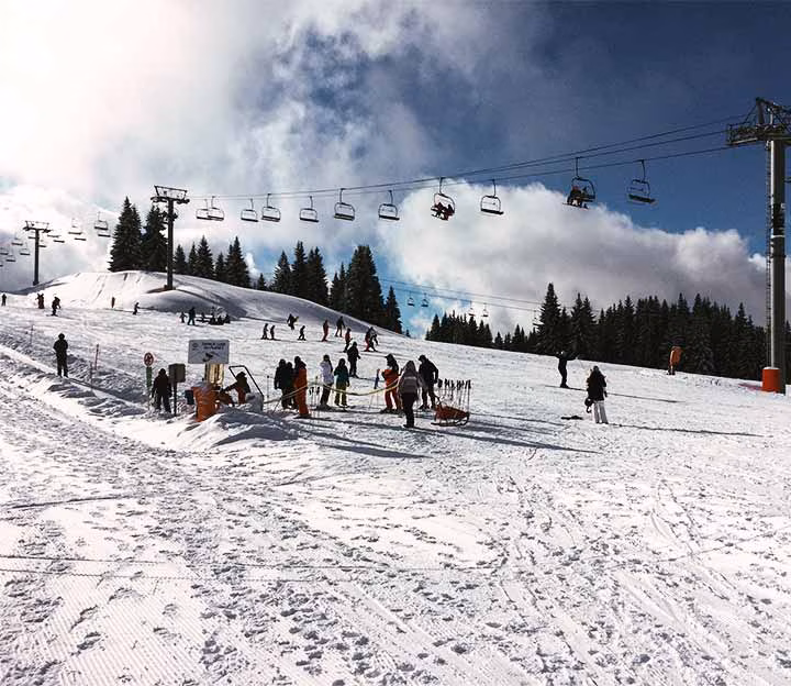 Skiers standing on a ski slope at the top of the mountain