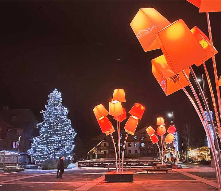 Colourful lights and a christmas tree in a village square
