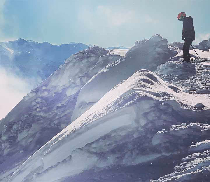 Skier standing on the top of a snowy chute