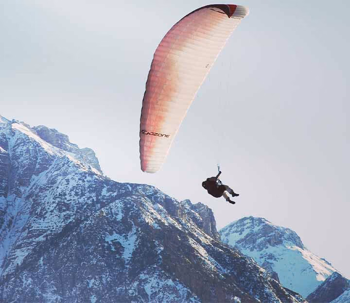 Person paragliding in the mountains