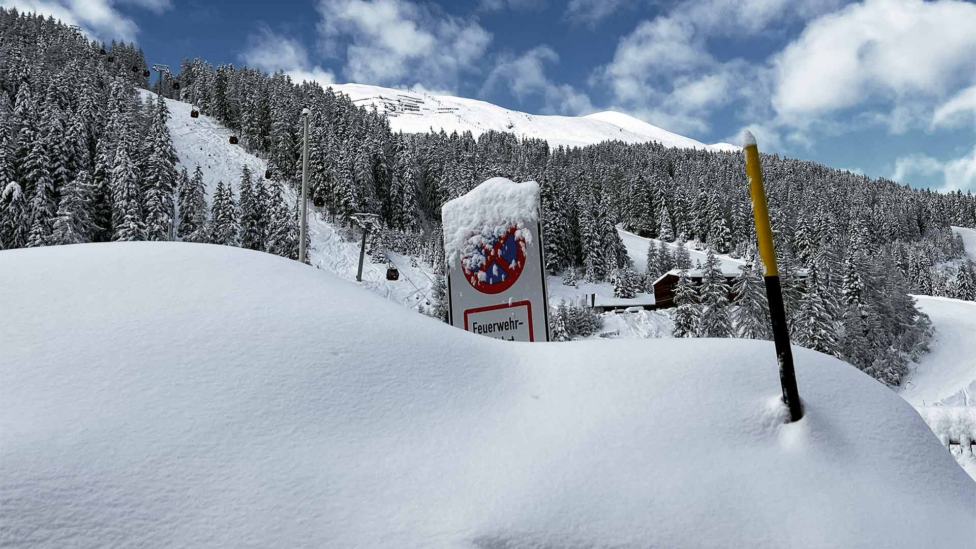 Wall of snow with buried road signs