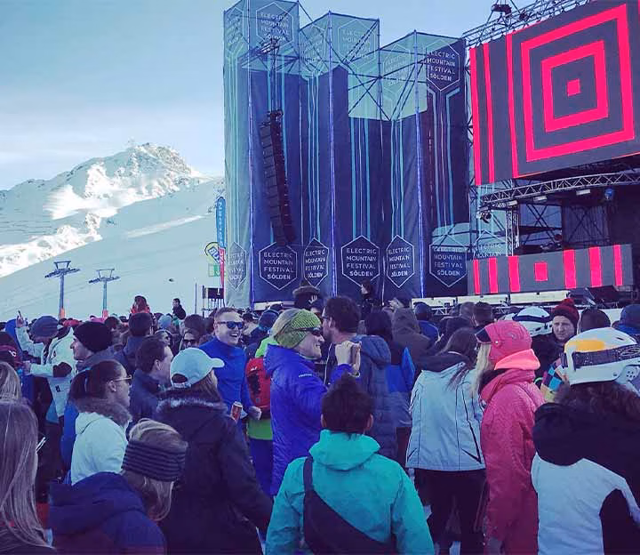 People watching a DJ set in snowy mountains