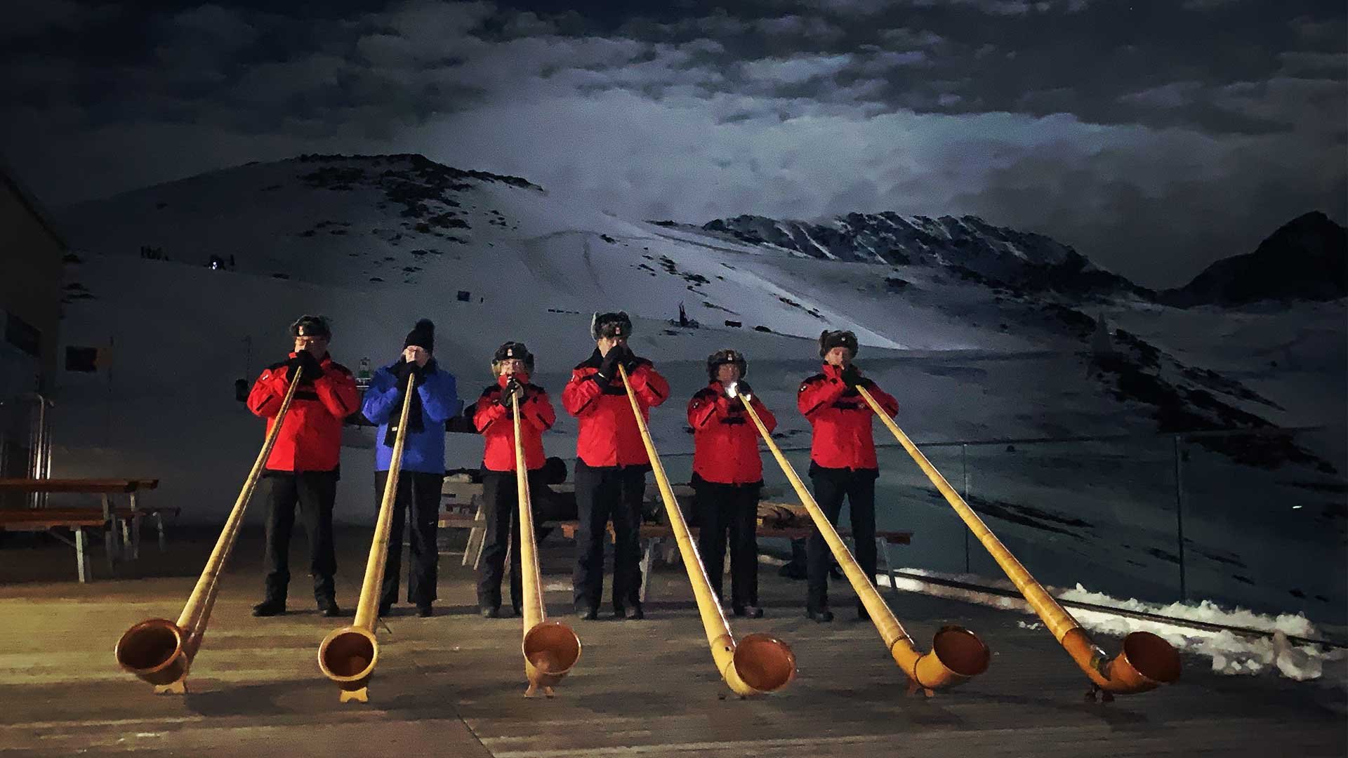 Band playing pipes on a night time terrace in the mountains