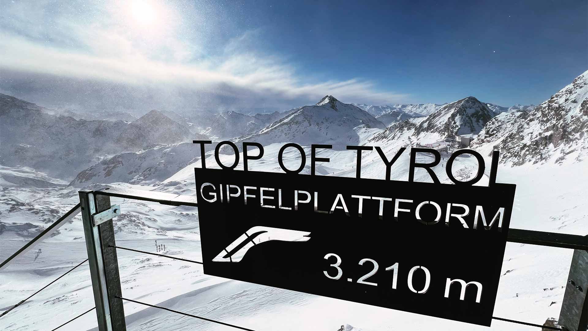 Sign in front of snowy mountain range