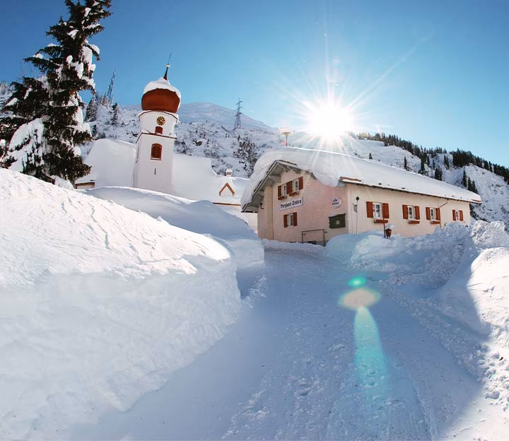 Snow covered building at sunset
