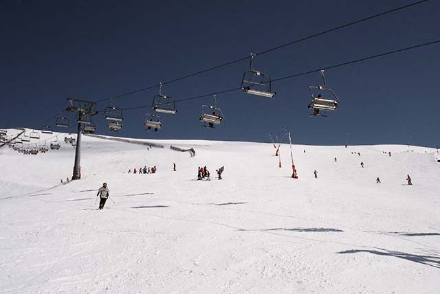 skiers riding down a ski piste