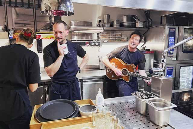 Chef playing a guitar in a kitchen